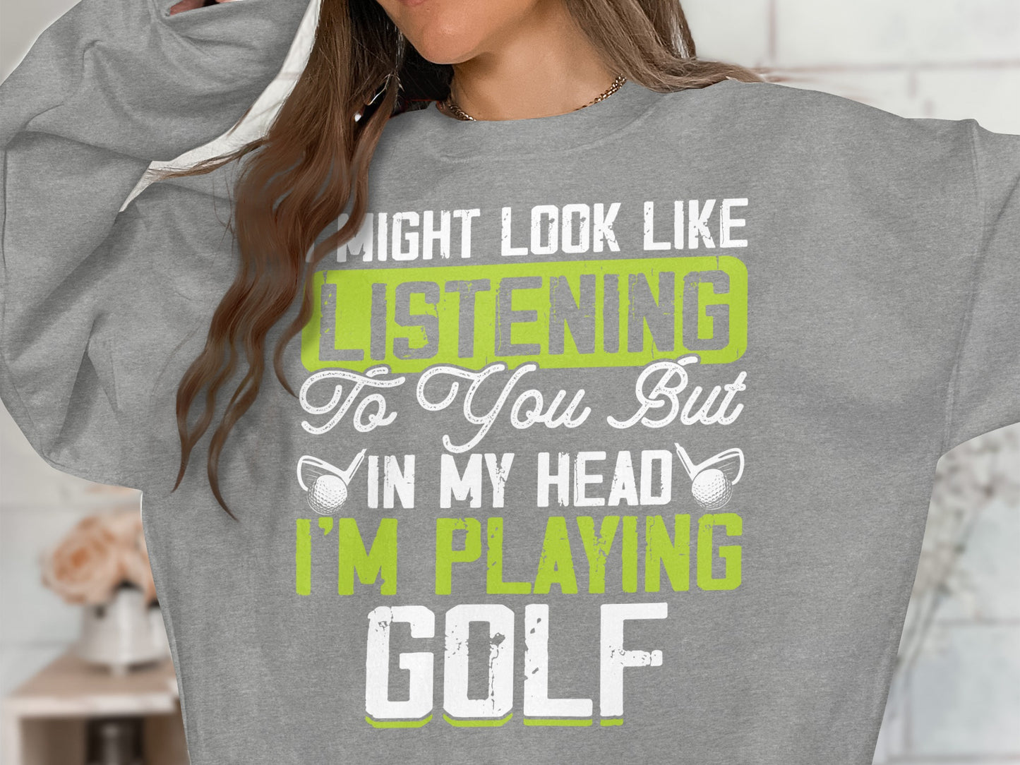 Grey sweatshirt with "Might Look Like Listening To You But In My Head I'm Playing Golf" text.