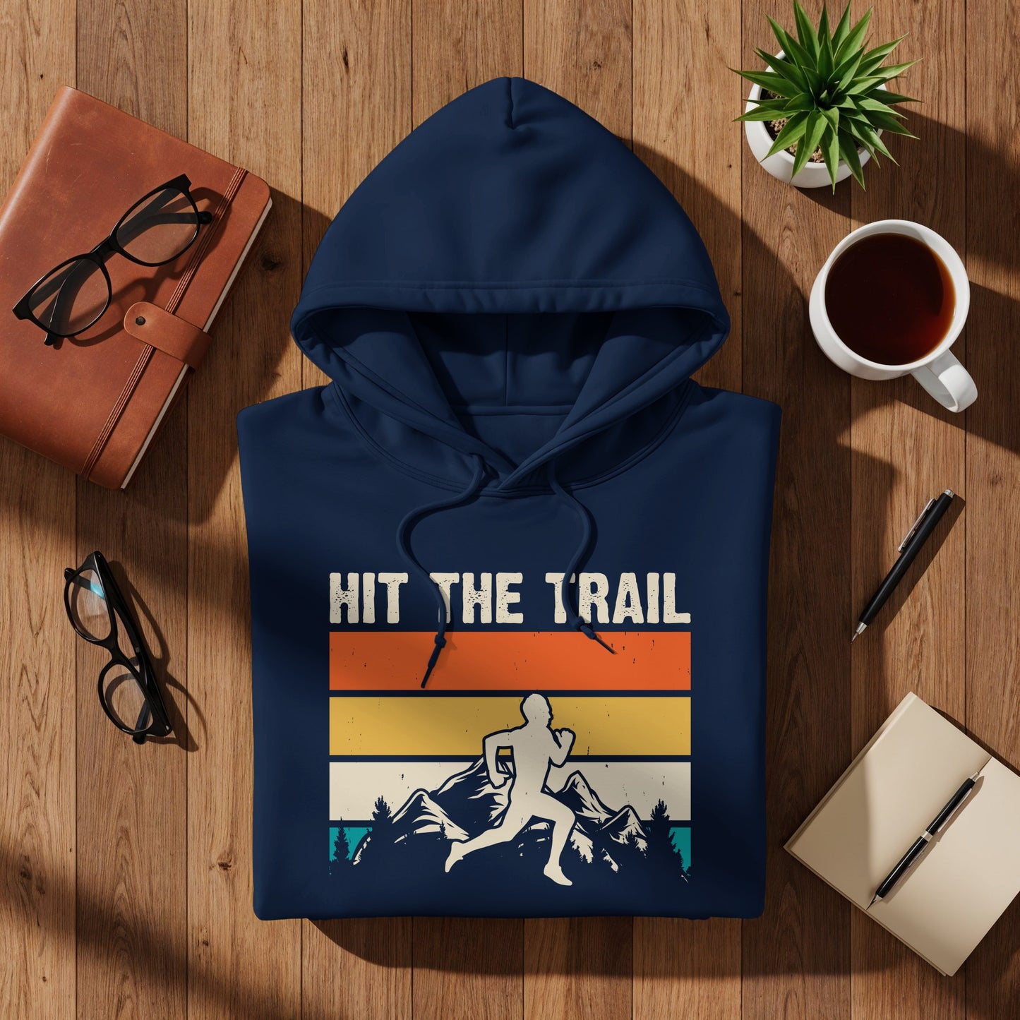 Navy hoodie with "HIT THE TRAIL" text and mountain runner graphic.