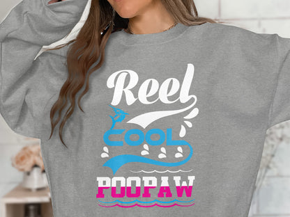 Gray sweatshirt with "Reel Cool POOPAW" text and fish graphic.