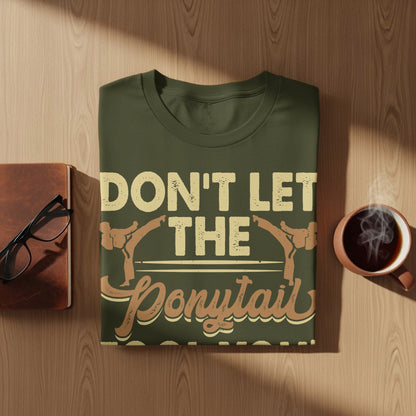 Olive green t-shirt with "Don't Let The Ponytail" text and martial arts figures.