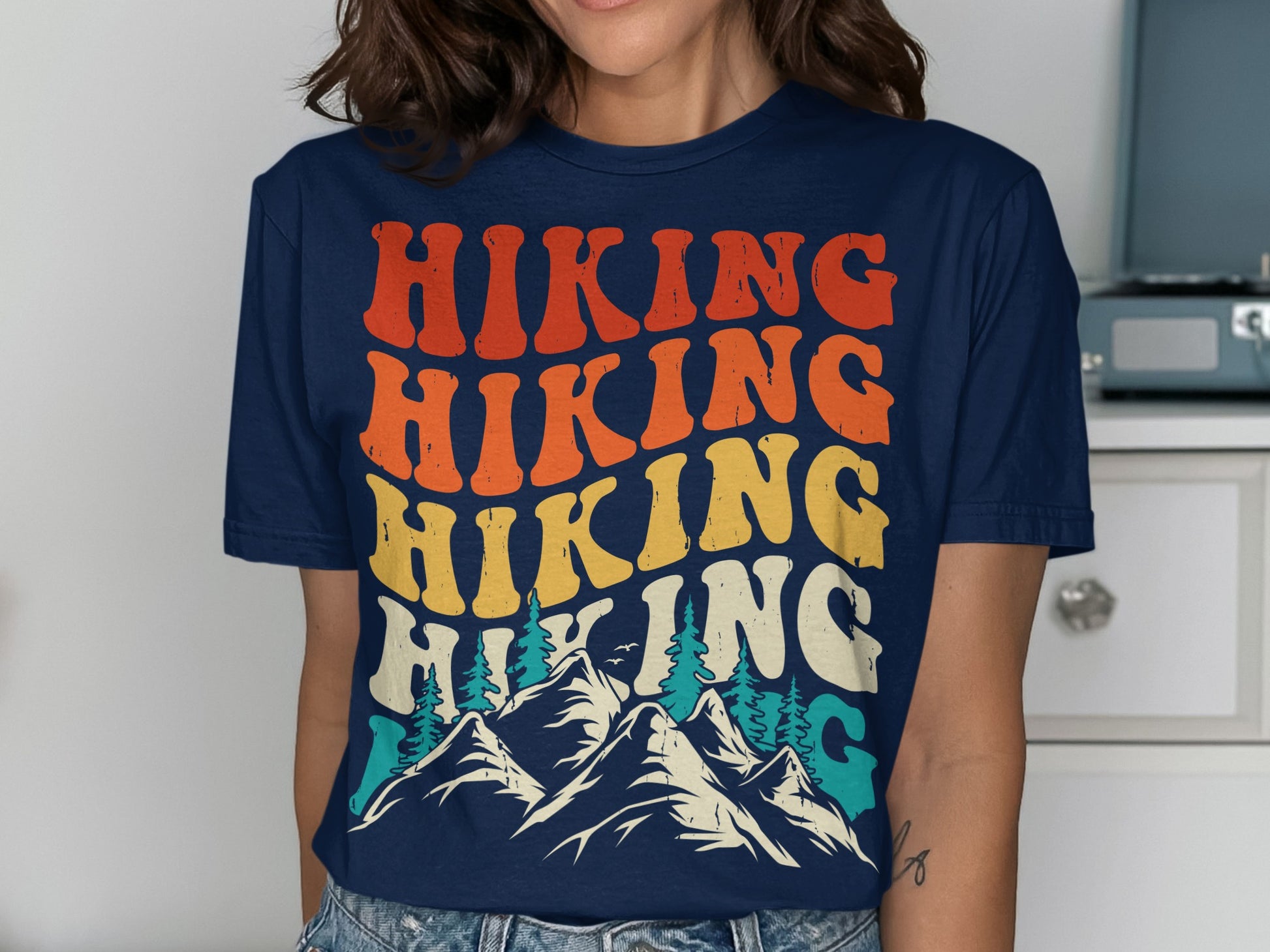 T-shirt with "Hiking" repeated in colorful retro font over mountains.