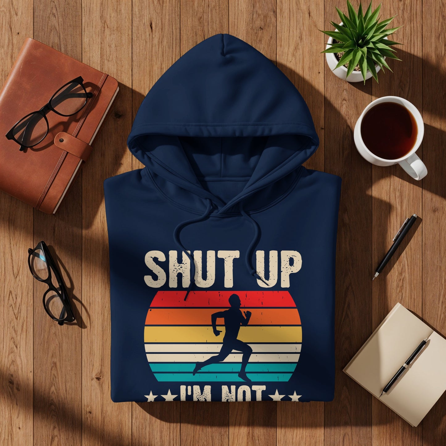 Navy hoodie with "SHUT UP I'M NOT RUNNING" text and vintage sunset runner graphic.