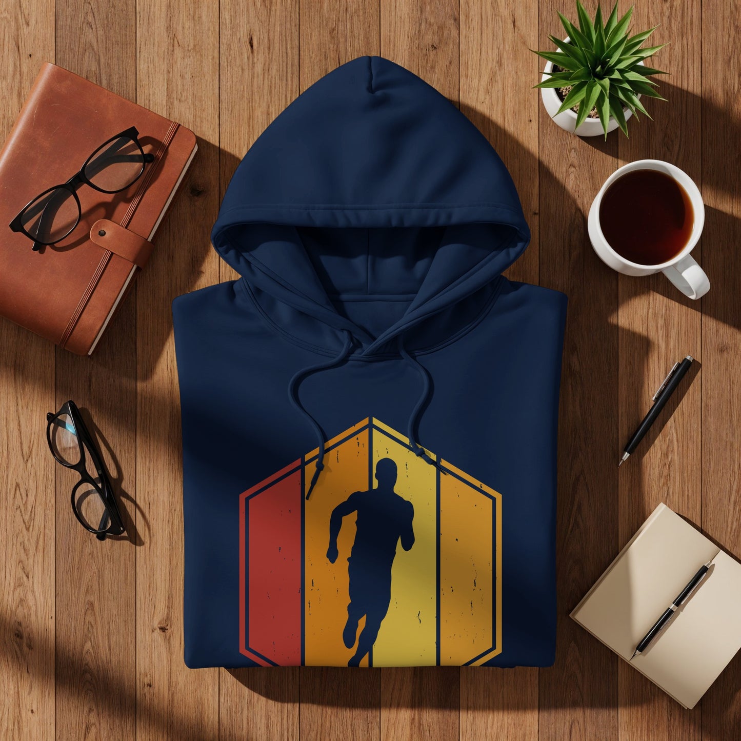 Navy hoodie with a stylized runner graphic on a wooden surface.