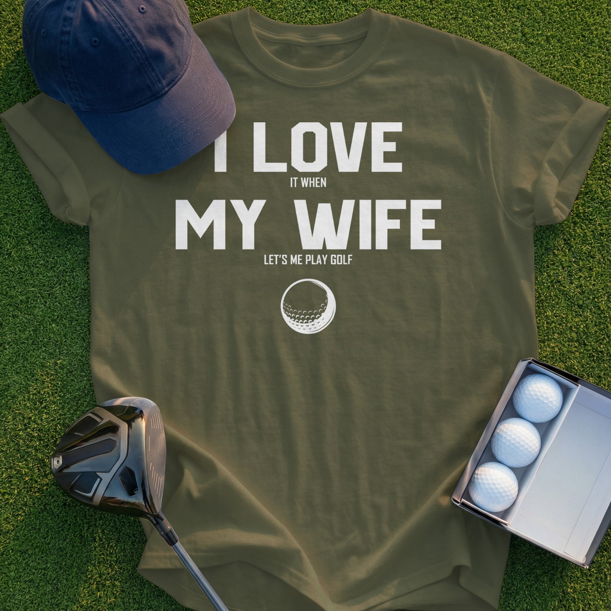 Olive green t-shirt with "I love my wife when she lets me play golf" and golf ball graphic.