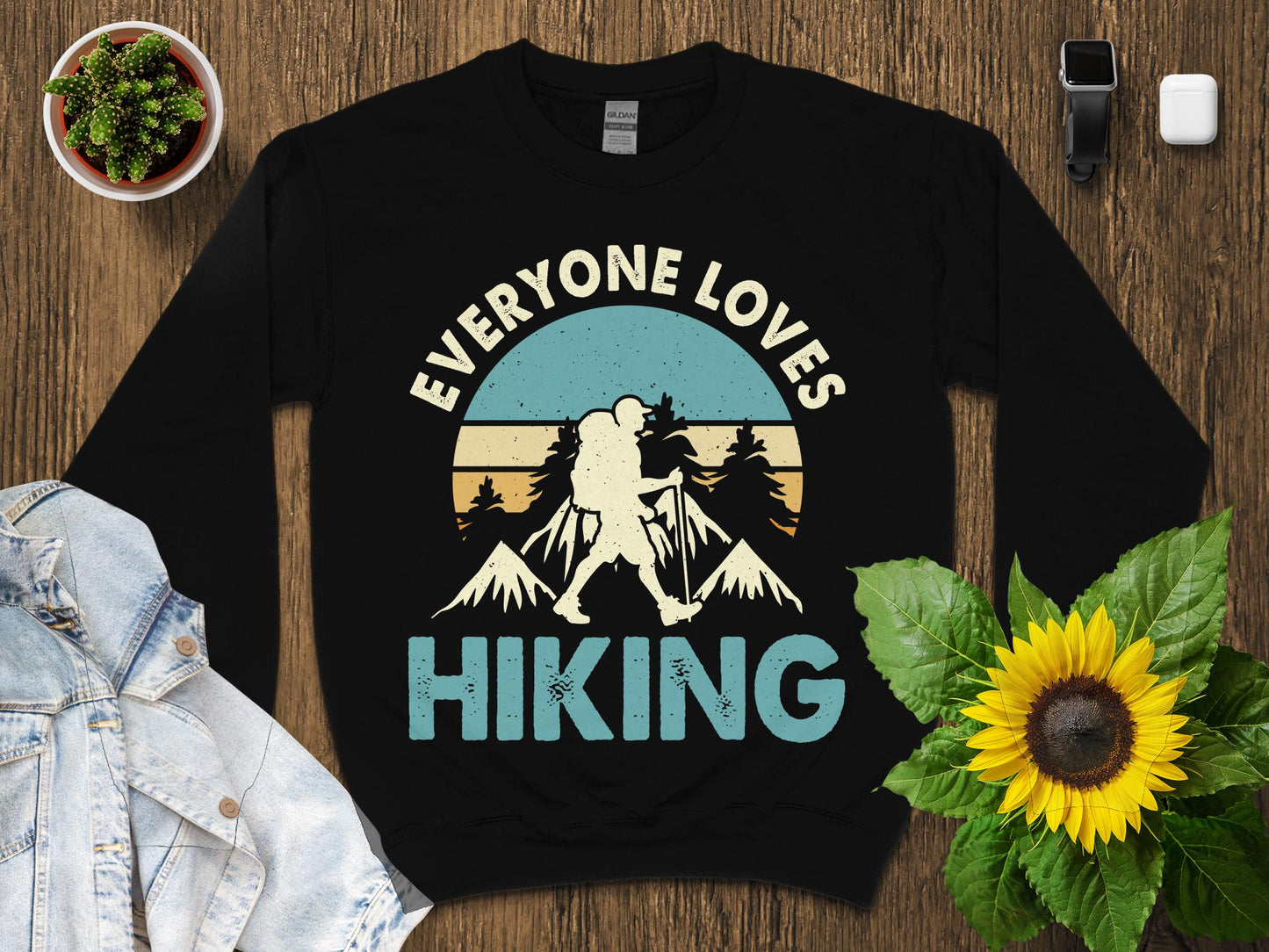 Black sweatshirt with "Everyone Loves Hiking" and mountain silhouette design.