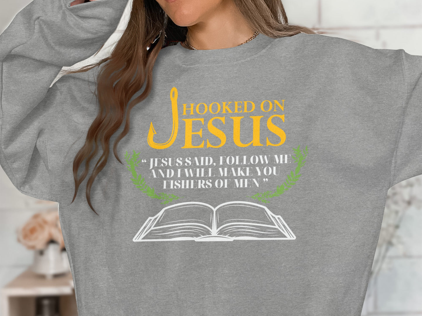 Grey sweatshirt with "Hooked on Jesus" text and a Bible graphic.