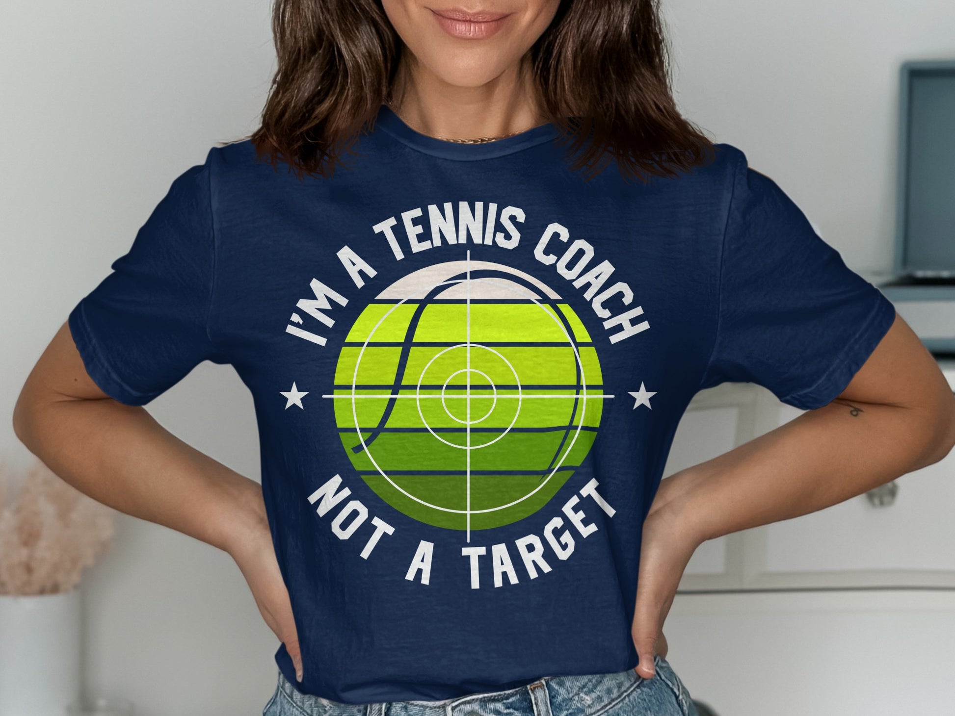 Navy t-shirt with "I'm a tennis coach not a target" and tennis ball graphic.