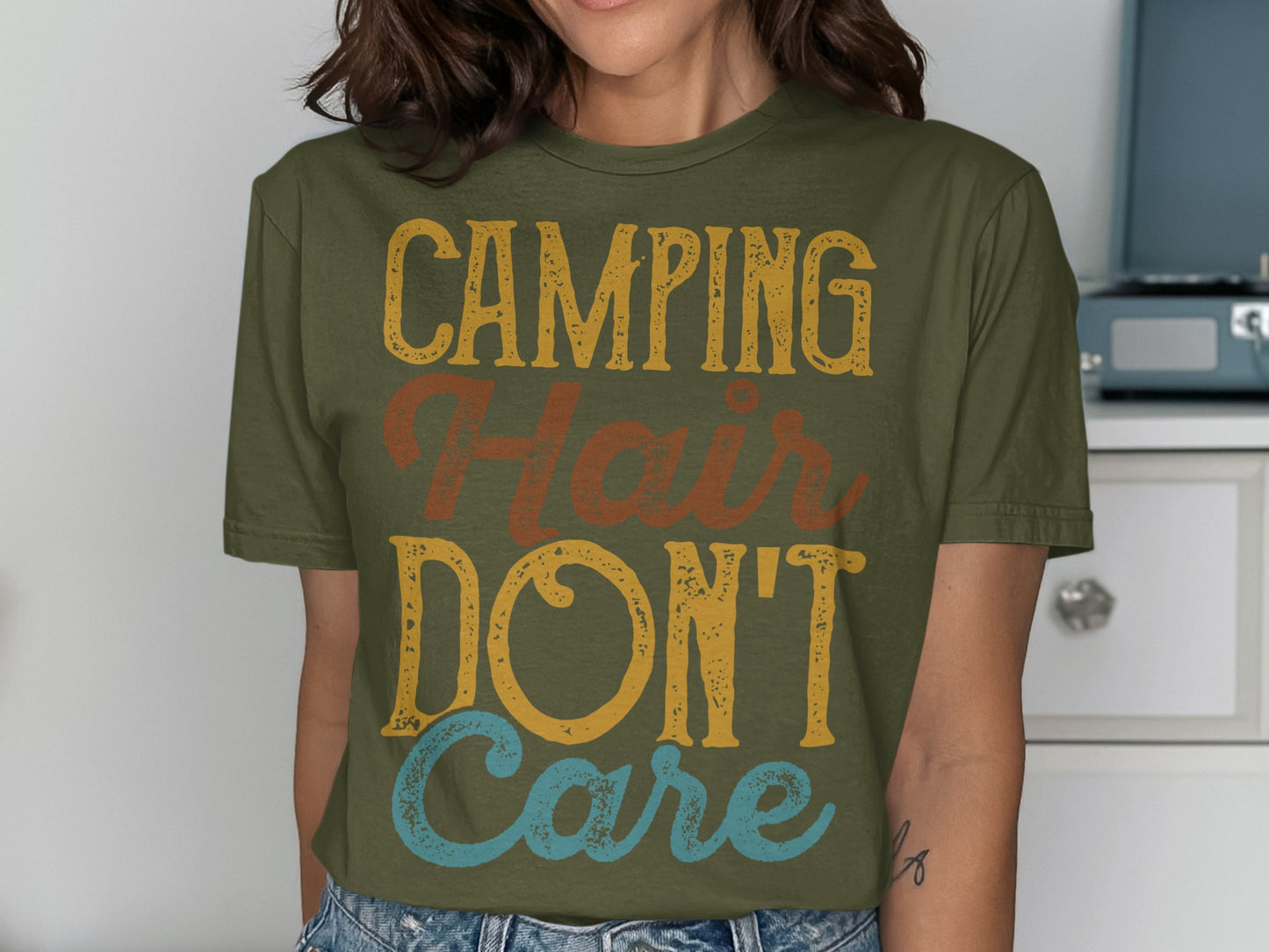 Olive green t-shirt with "Camping Hair Don't Care" text.