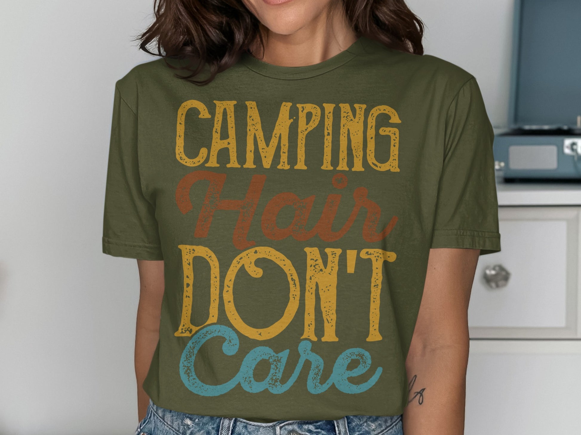 Olive green t-shirt with "Camping Hair Don't Care" text.
