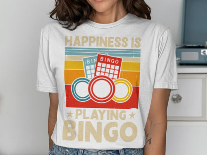 "Happiness is playing Bingo" text on a t-shirt with bingo cards and chips.