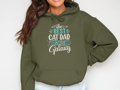 Olive green hoodie with text "The Best Cat Dad In The Galaxy".
