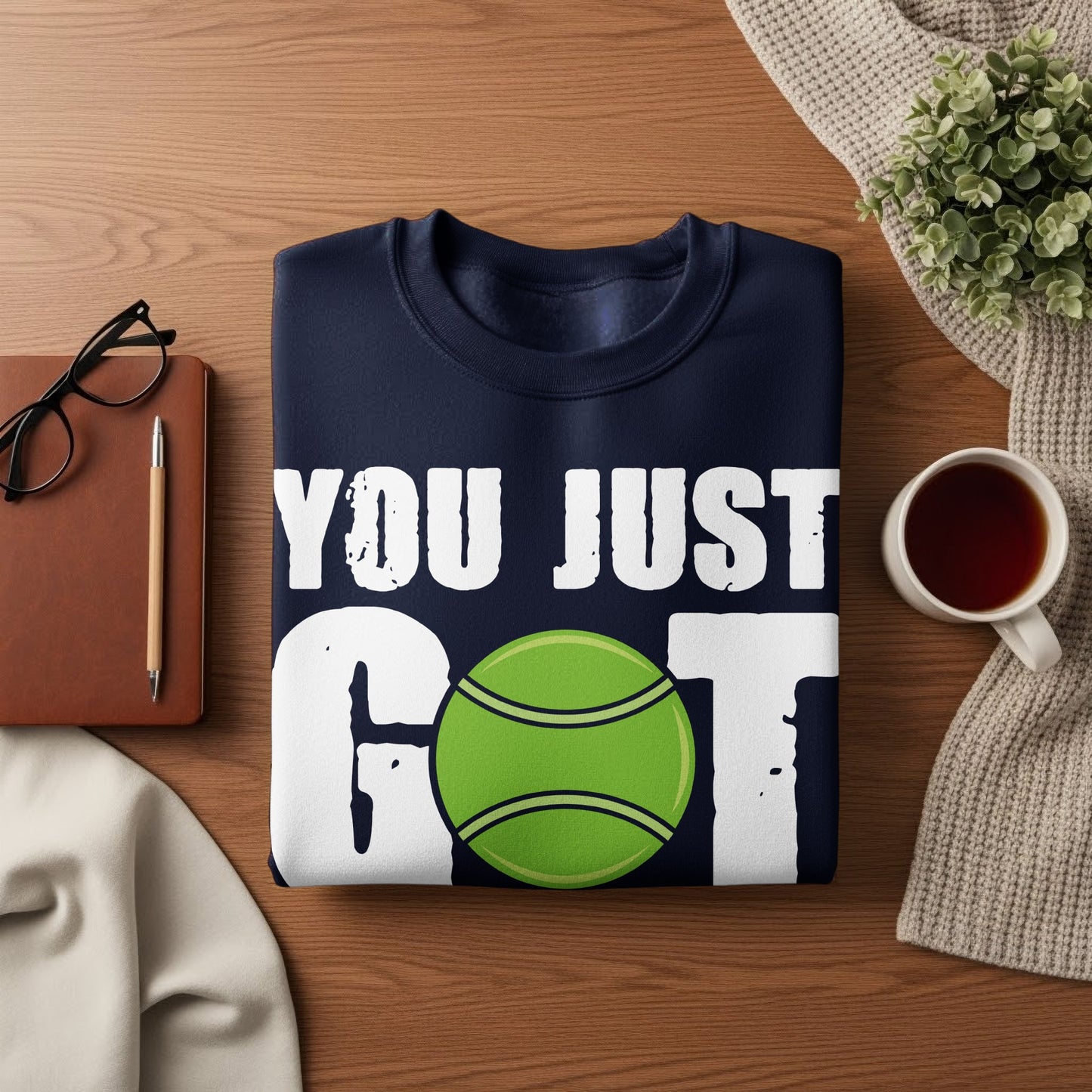 Navy sweatshirt with "YOU JUST GOT" and a tennis ball graphic.