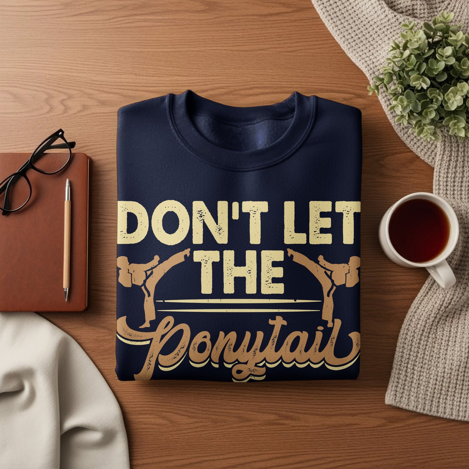 Navy sweatshirt with "Don't Let The Ponytail" text and karate graphics.