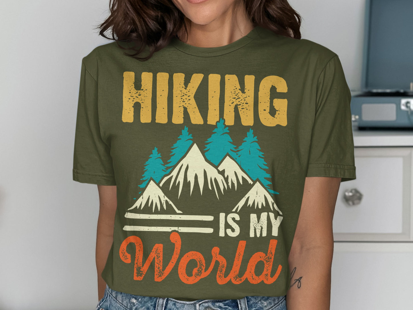 Green t-shirt with "Hiking Is My World" text and mountain graphic.