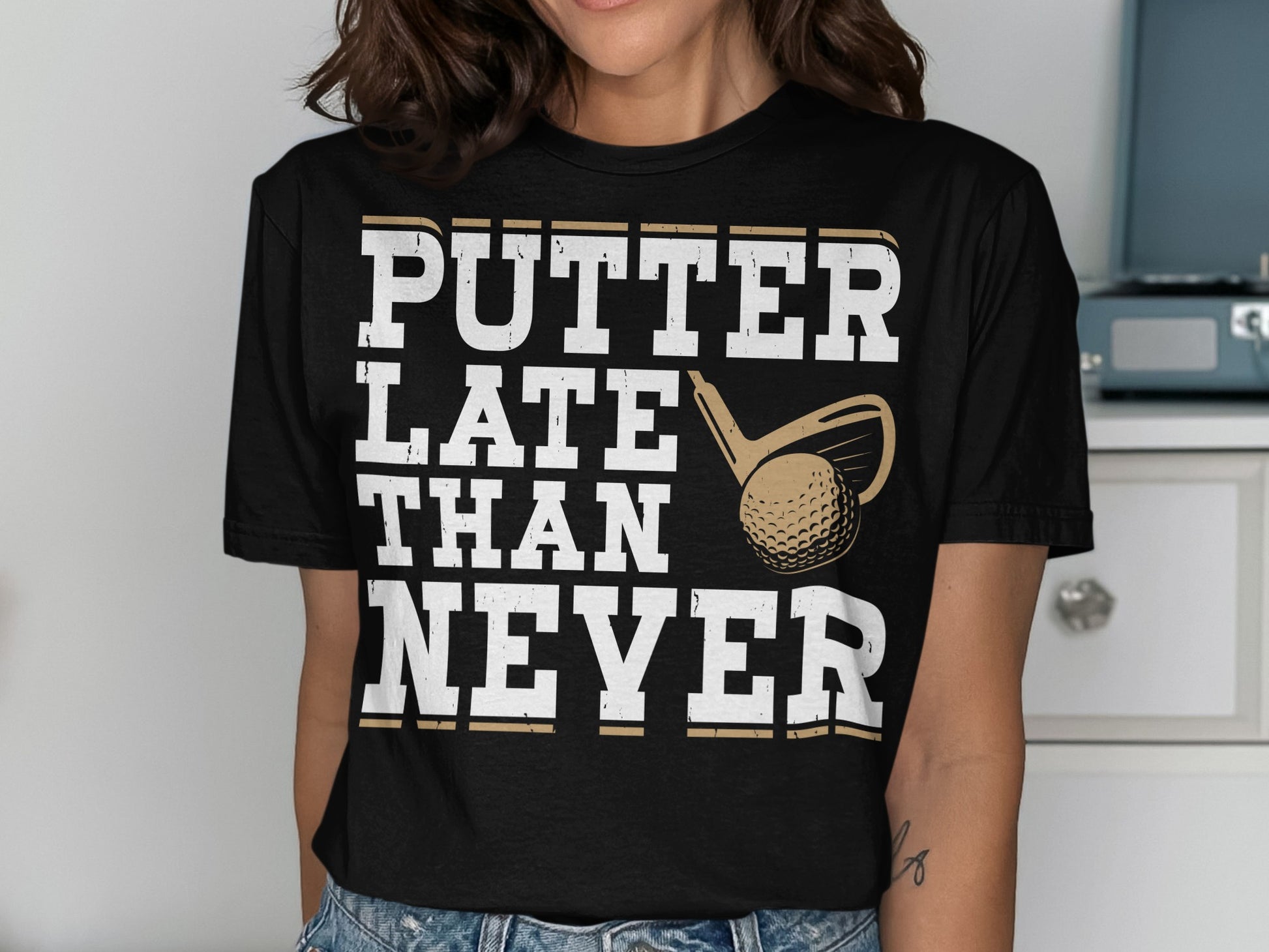 Black t-shirt with "PUTTER LATE THAN NEVER" text and golf club and ball graphic.