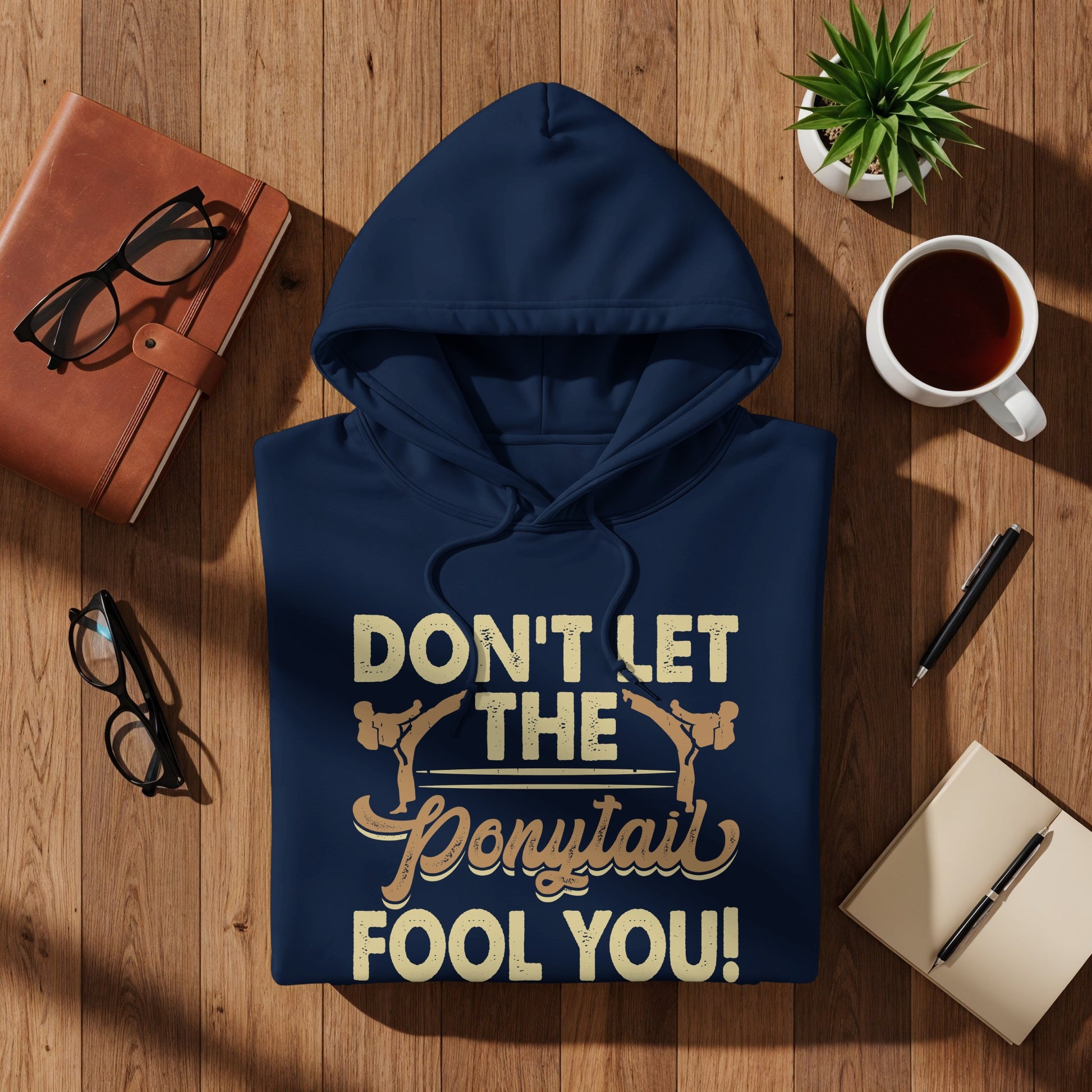 Navy hoodie with "DON'T LET THE PONYTAIL FOOL YOU!" text.