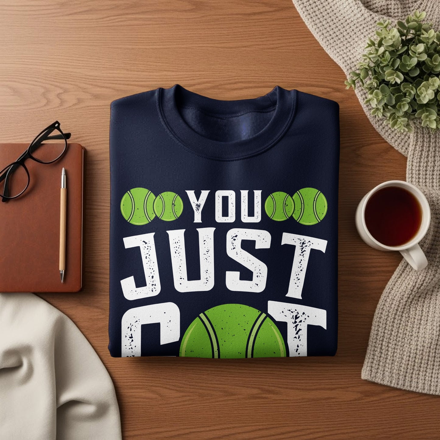Navy sweatshirt with "YOU JUST" and tennis ball graphics.