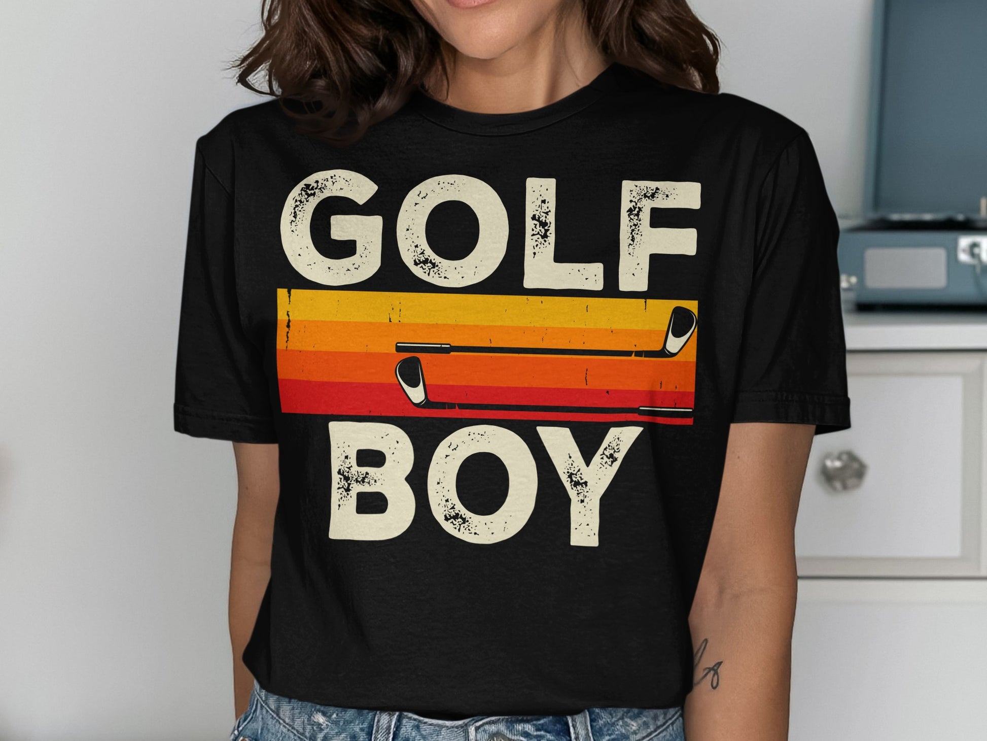 Black t-shirt with "GOLF BOY" text and golf clubs on a striped background.