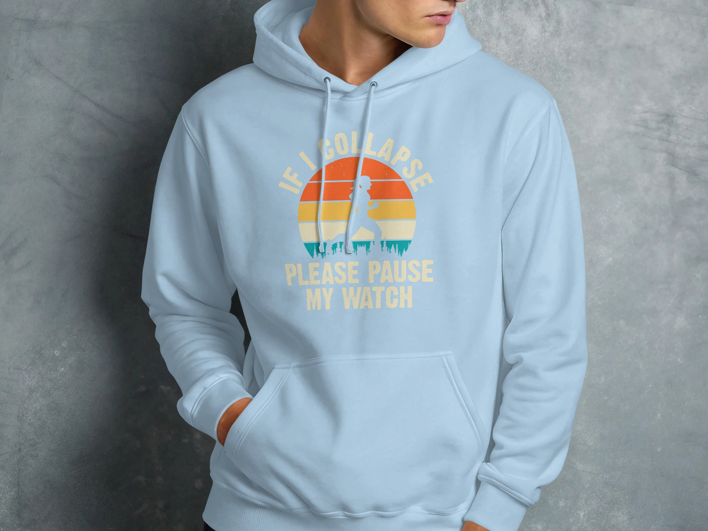 Light blue hoodie with "IF I COLLAPSE PLEASE PAUSE MY WATCH" text and sunset graphic.