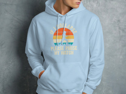 Light blue hoodie with "IF I COLLAPSE PLEASE PAUSE MY WATCH" text and sunset graphic.