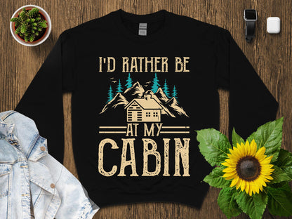 Black sweatshirt with "I'd rather be at my cabin" text and mountain graphic.