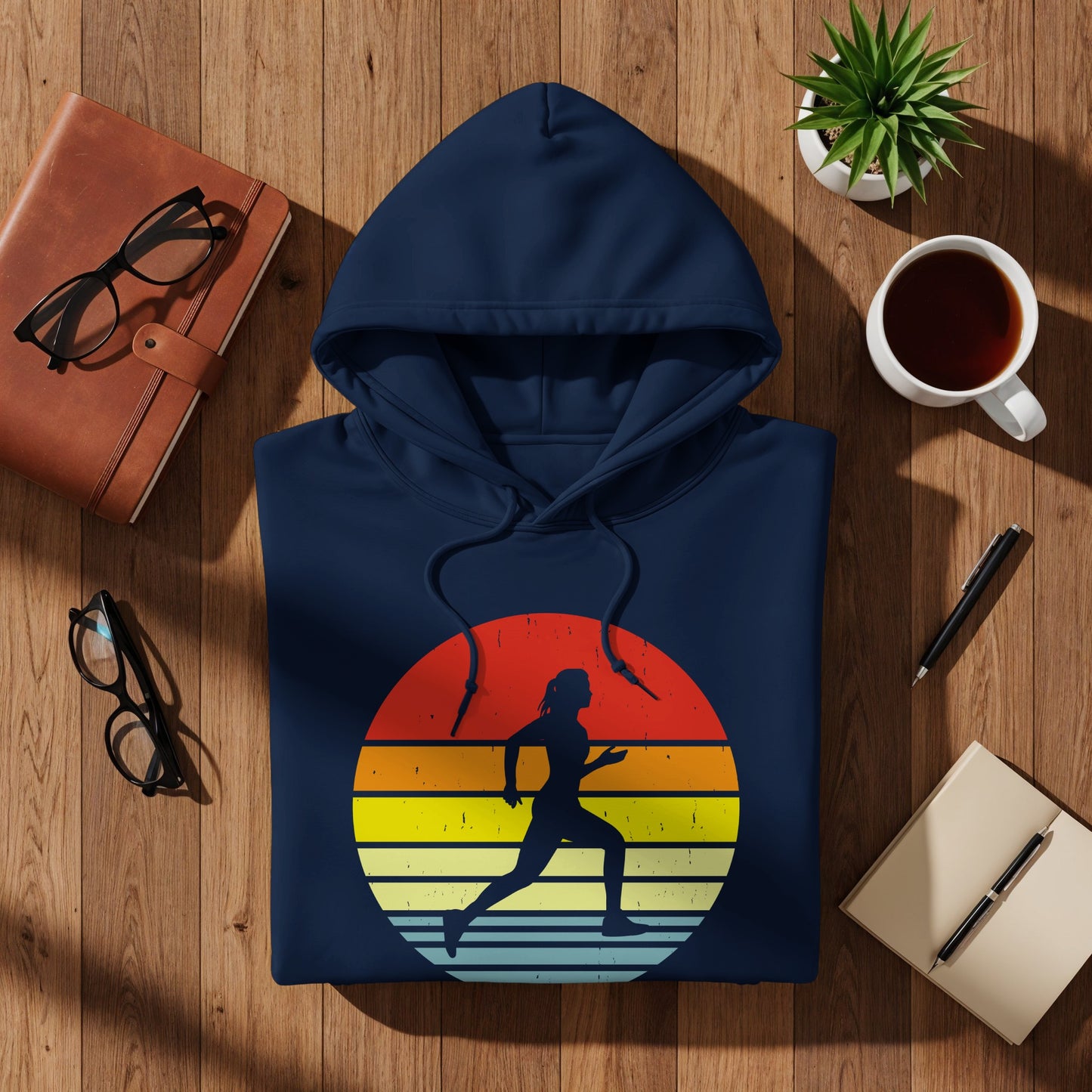 Navy hoodie with a sunset graphic of a running woman.