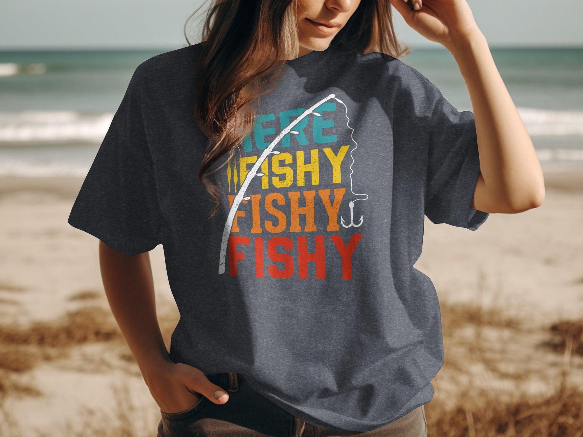 Woman wearing dark t-shirt with "Fishy Fishy Fishy" text and fishing rod graphic.