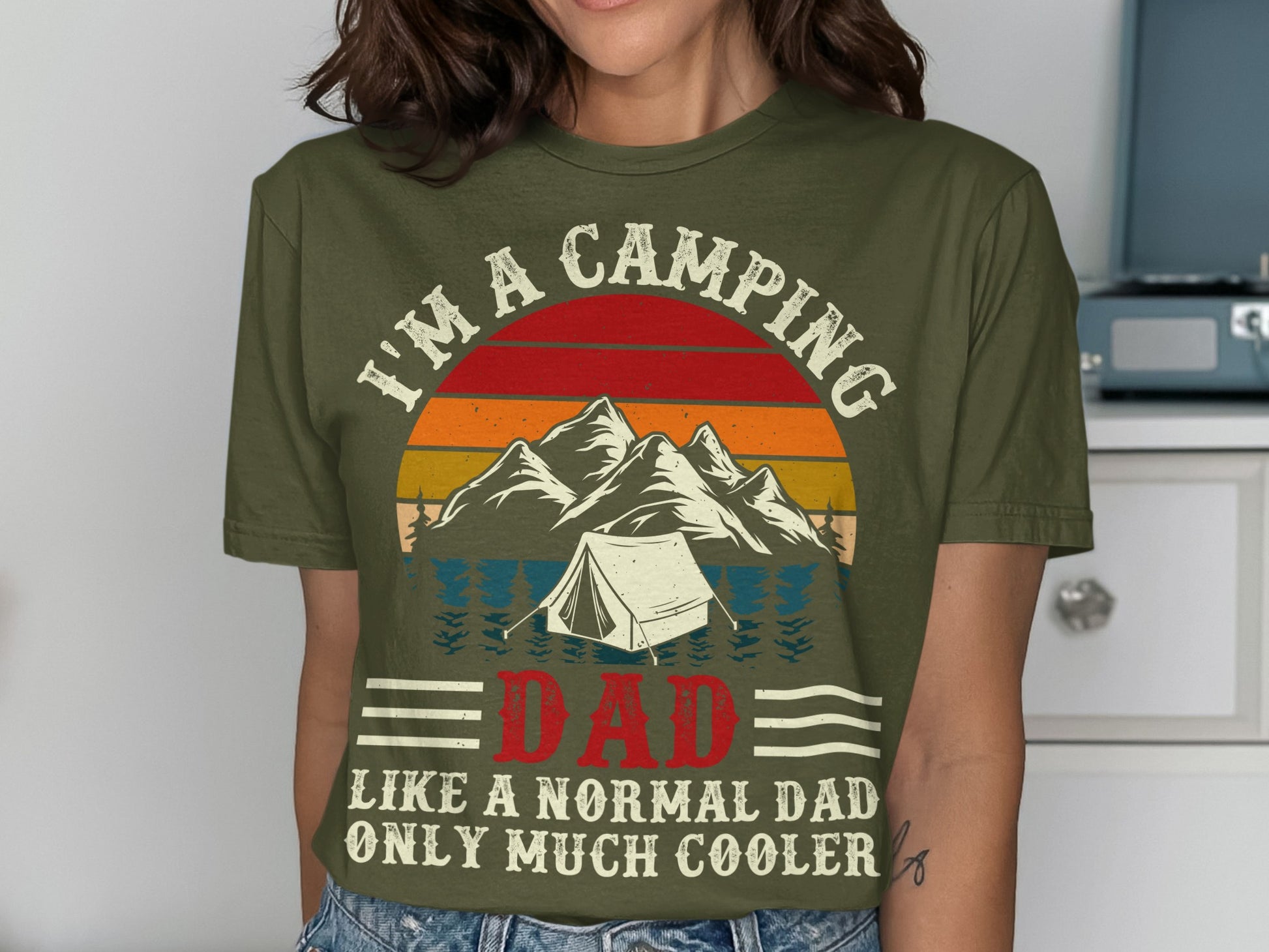 Olive green t-shirt with mountain and tent graphic and "I'm a camping dad" text.