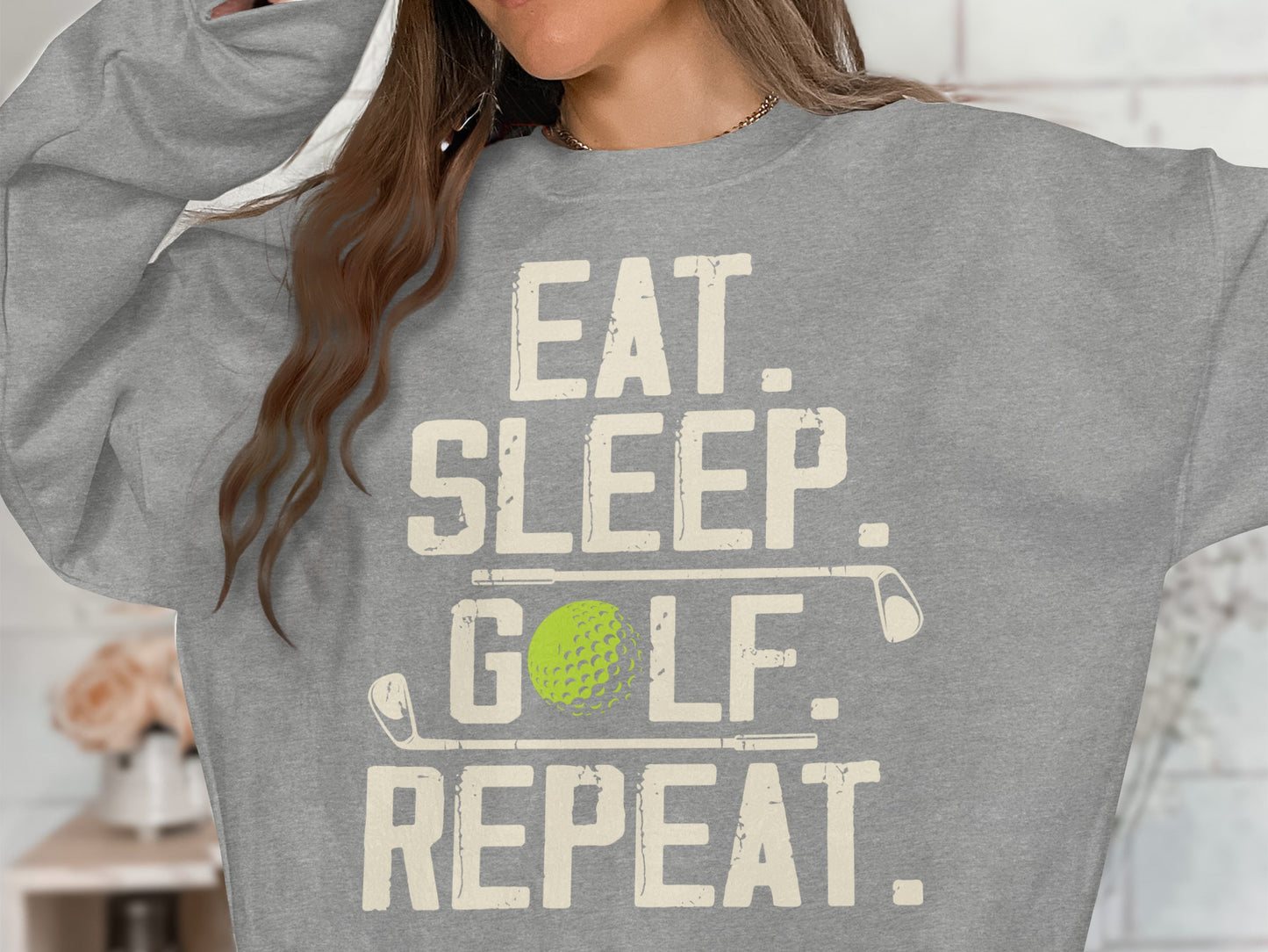 Gray sweatshirt with "Eat. Sleep. Golf. Repeat." text and golf ball.