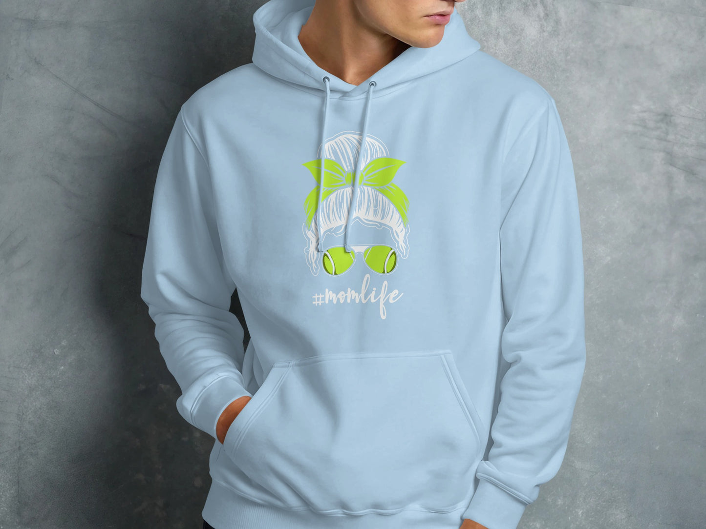 Light blue hoodie with "#momlife" graphic of messy bun, sunglasses, and tennis balls.