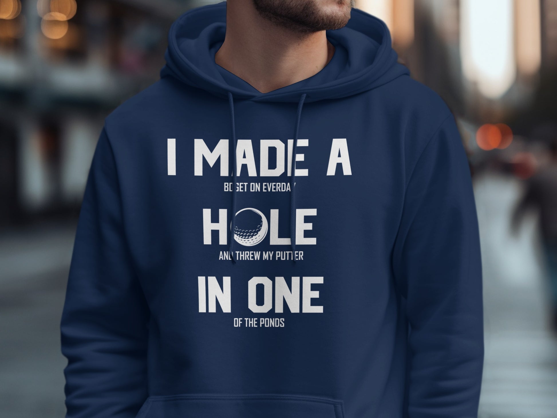 Navy hoodie with "I MADE A HOLE IN ONE" text and golf ball graphic.