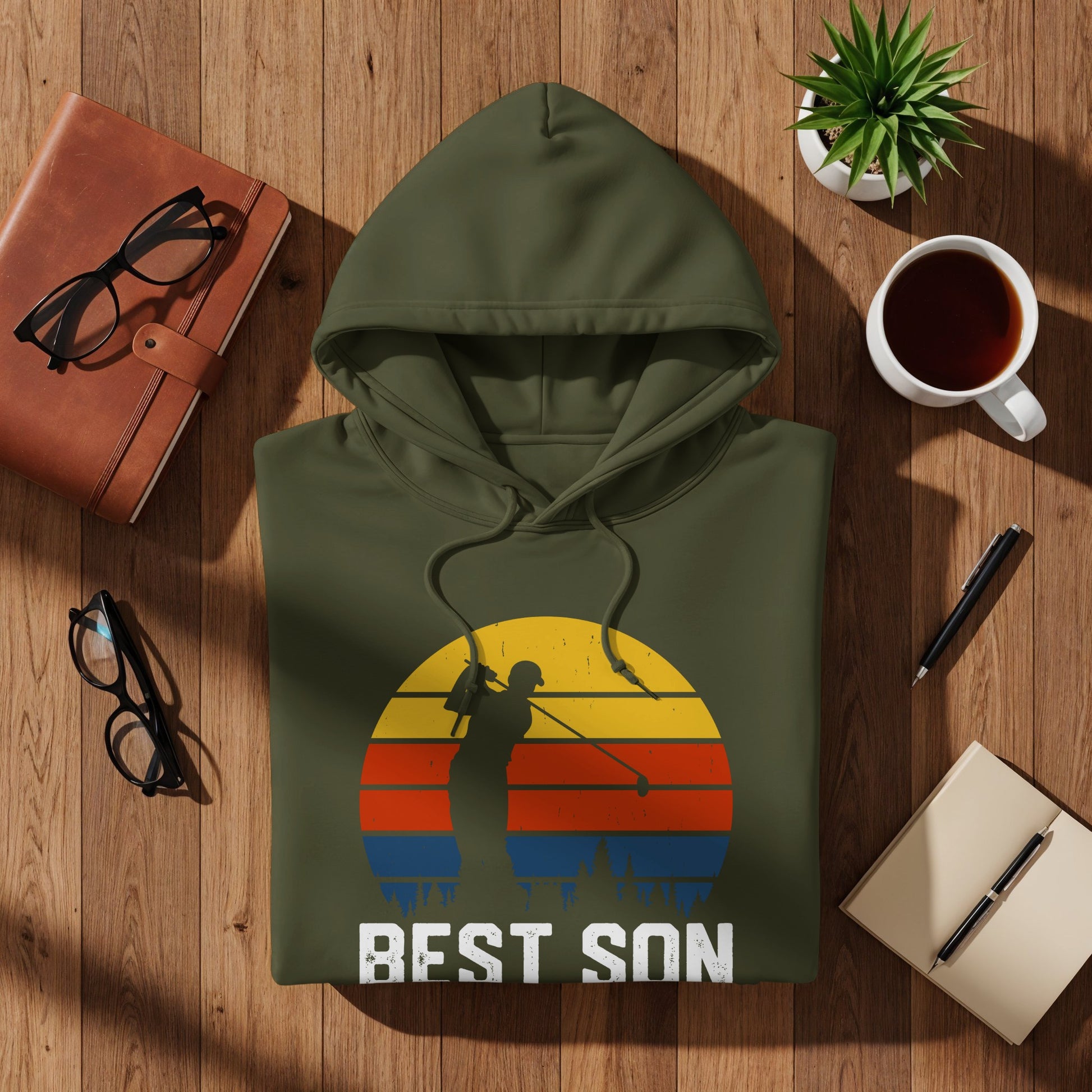 Olive green hoodie with a graphic of a golfer and a colorful sunset.