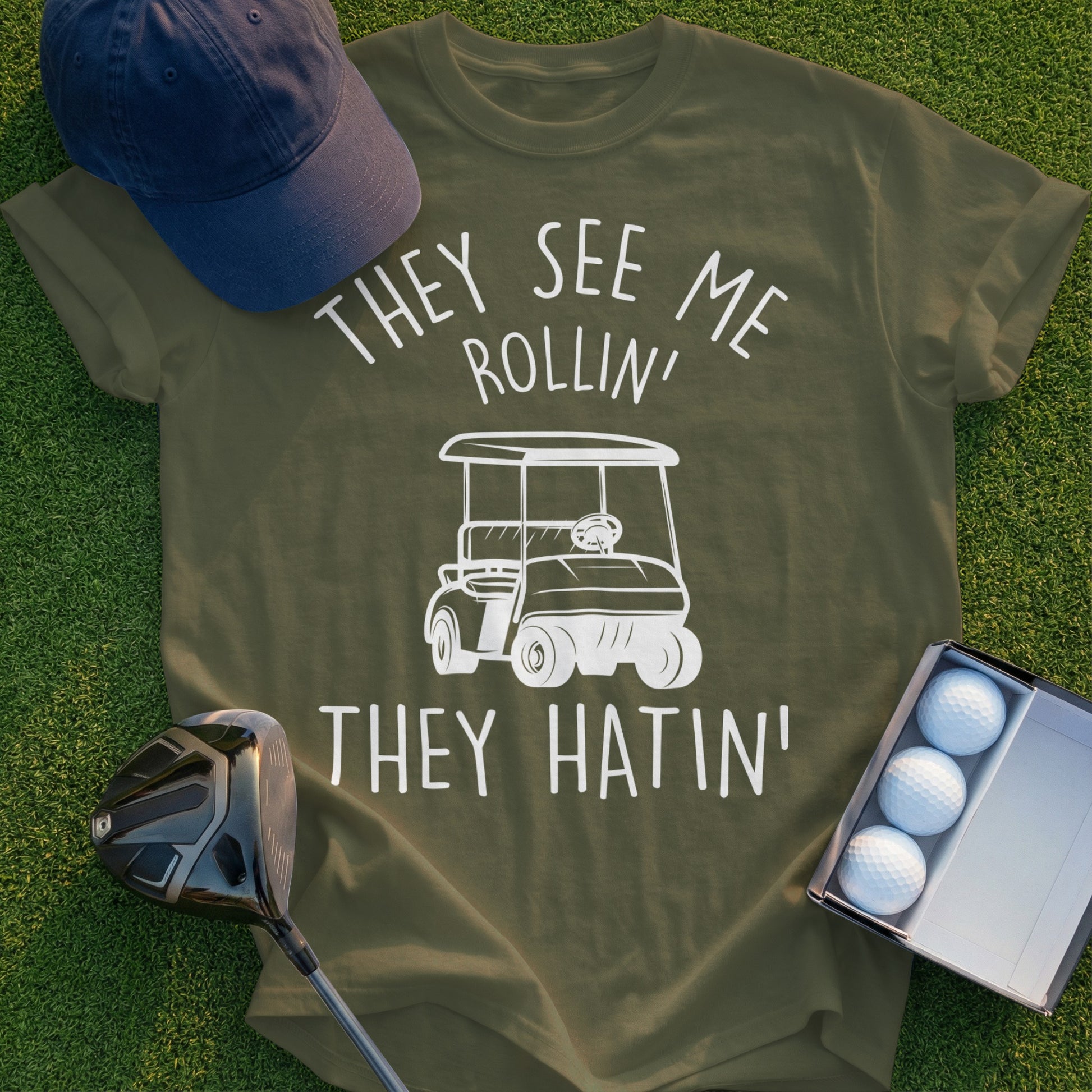 Olive t-shirt with white graphic: "They See Me Rollin' They Hatin'" and a golf cart.