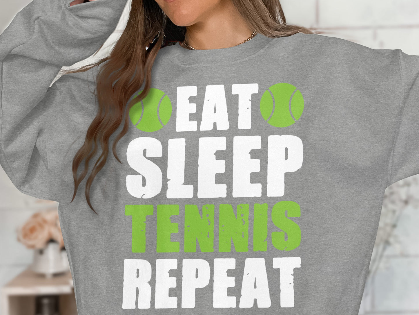 Grey sweatshirt with "Eat Sleep Tennis Repeat" text and tennis balls.