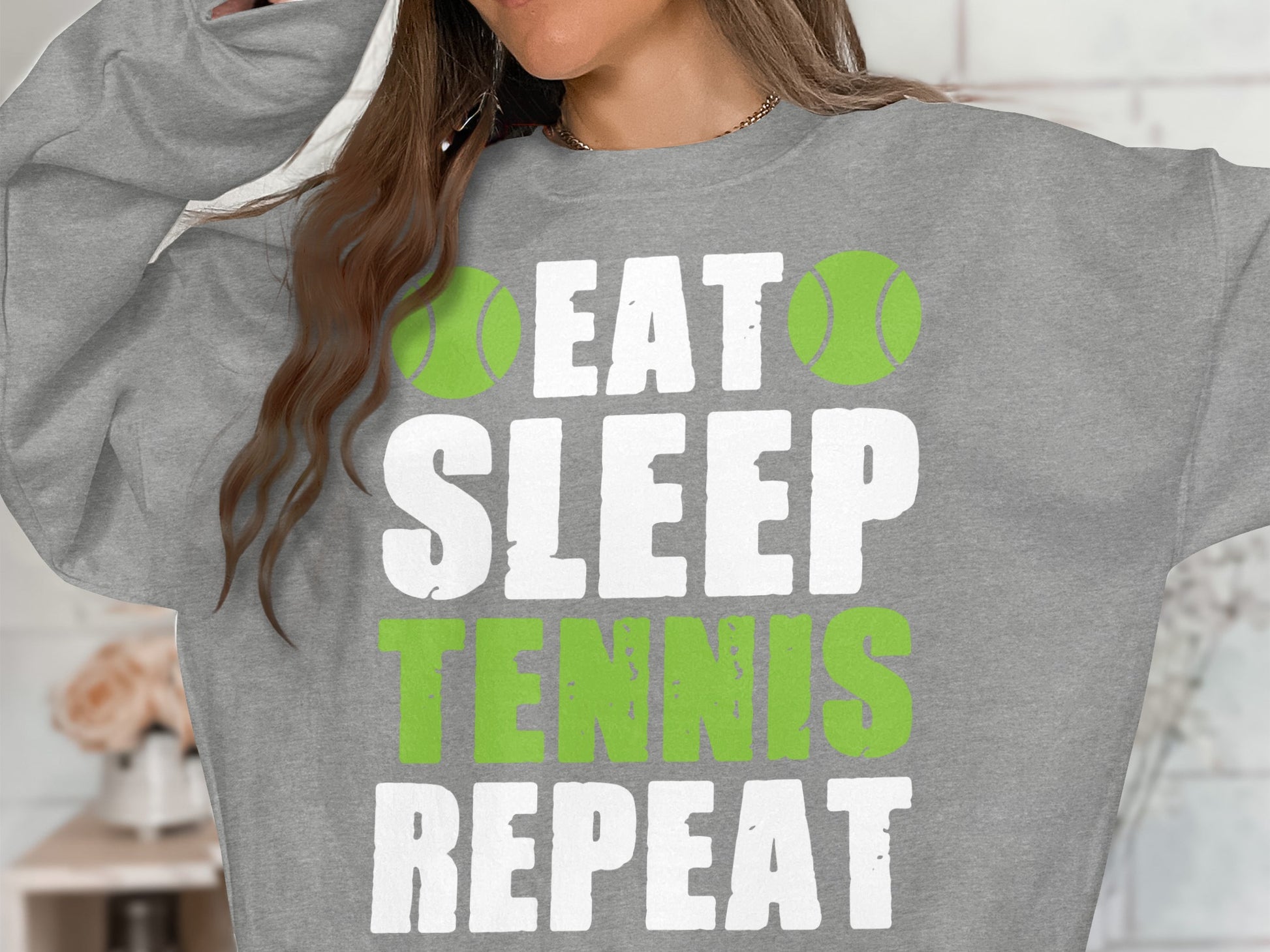 Grey sweatshirt with "Eat Sleep Tennis Repeat" text and tennis balls.