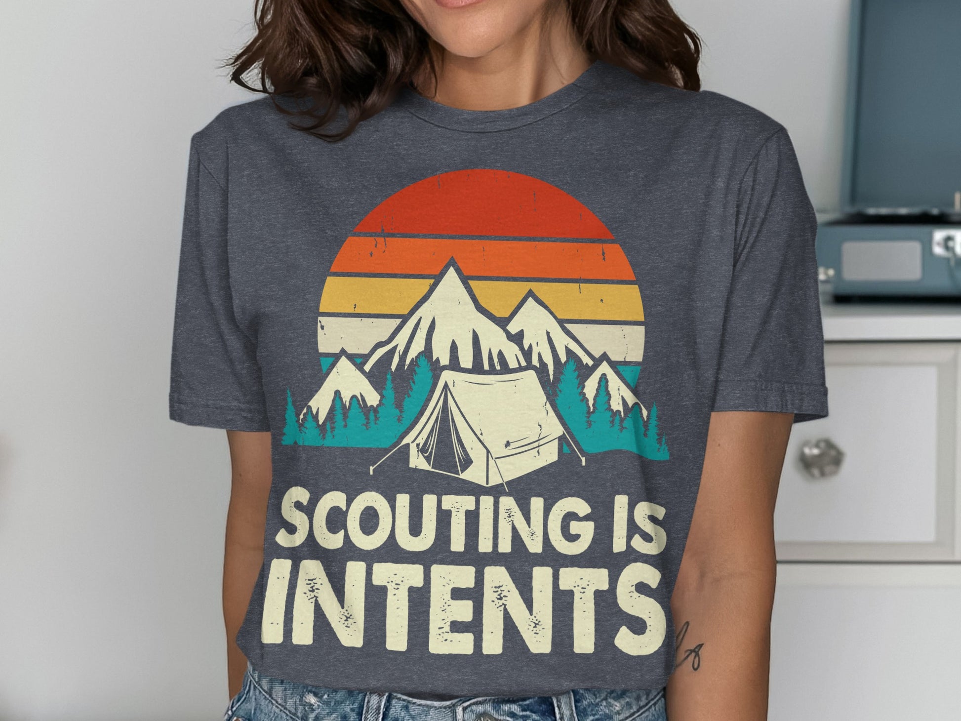 T-shirt with "Scouting is Intents" text, mountains, tent, and sunset graphic.