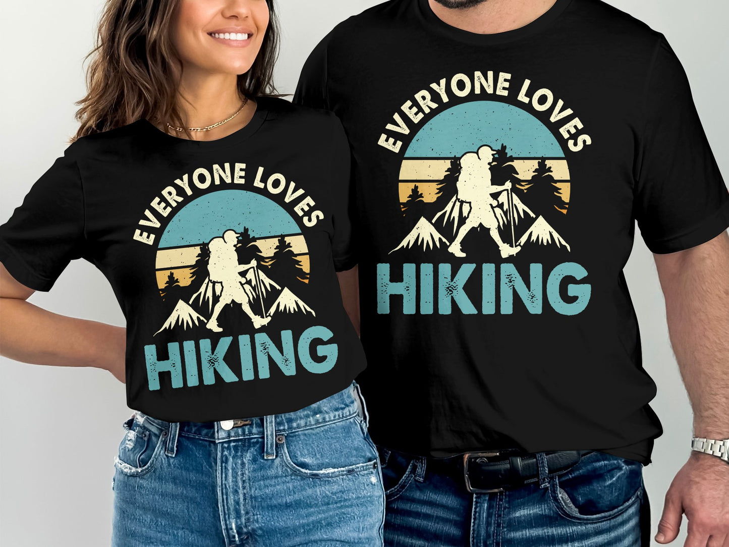 Couple wearing matching t-shirts with "Everyone Loves Hiking" text and mountain graphic.