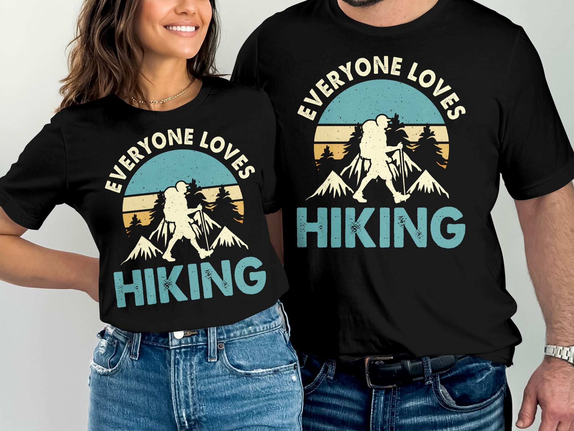 Couple wearing matching t-shirts with "Everyone Loves Hiking" text and mountain graphic.