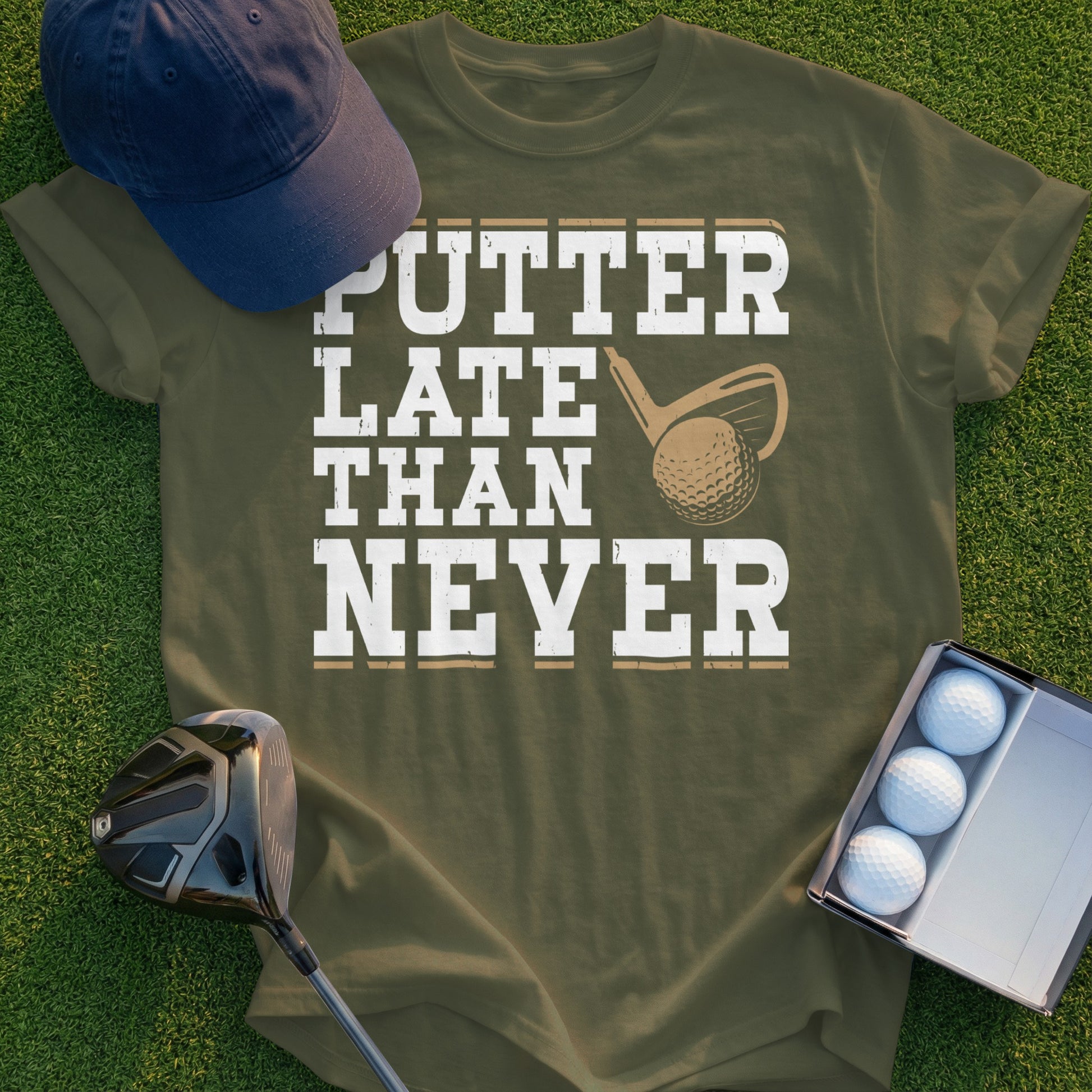Olive t-shirt with "PUTTER LATE THAN NEVER" text and golf accessories.