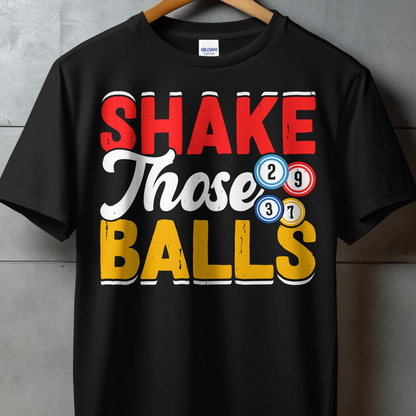 Black t-shirt with bold red text "SHAKE" and white text "THOSE BALLS" with bingo balls.