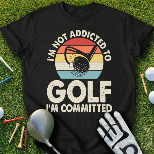 Black t-shirt with "I'm Not Addicted To Golf, I'm Committed" and a golf ball.