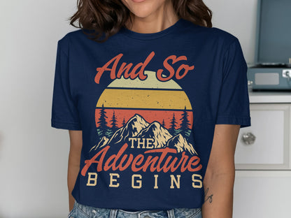 Navy t-shirt with "And so the adventure begins" mountain sunset graphic.