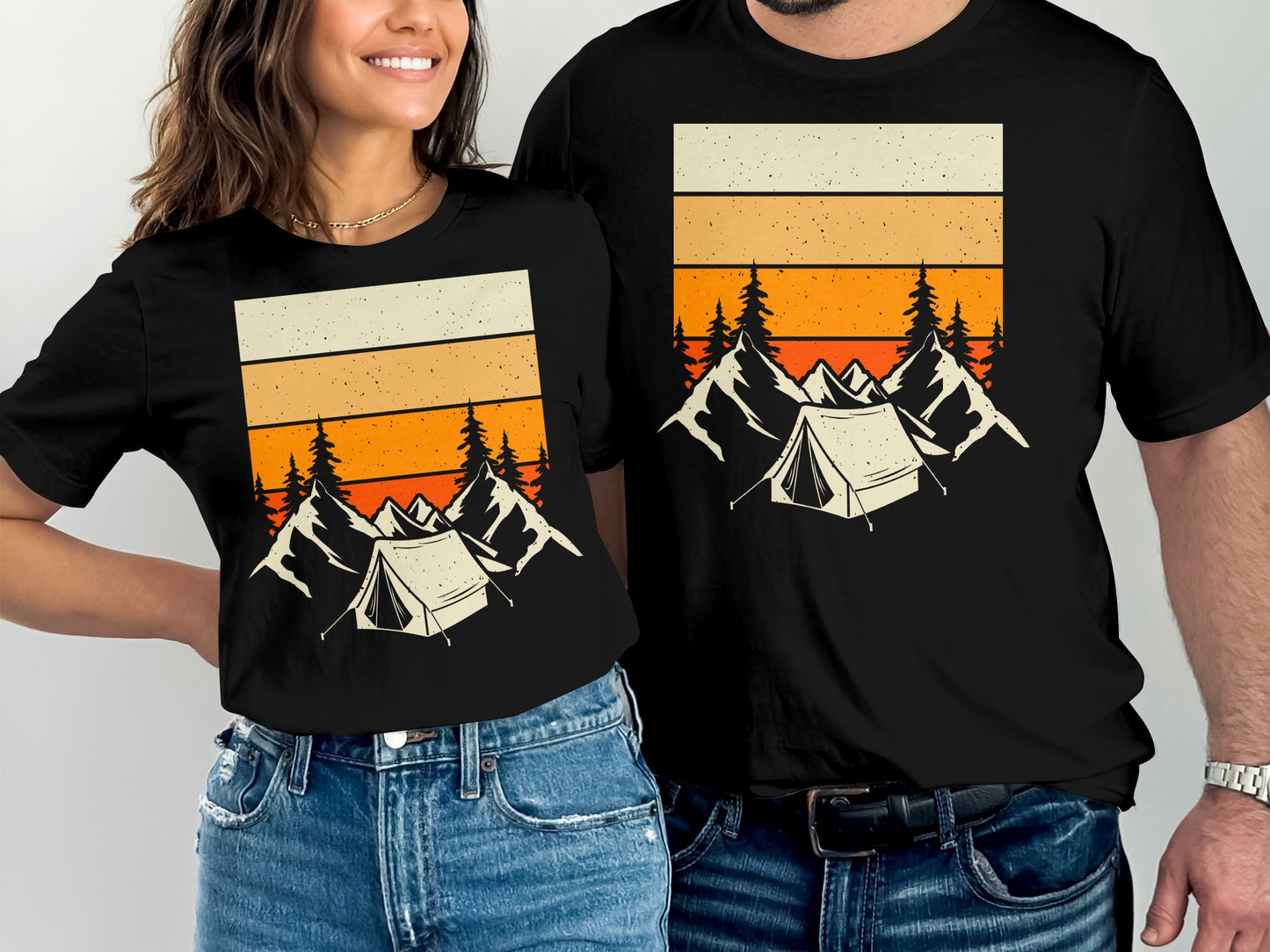 Matching black t-shirts with mountain and tent graphic featuring orange sunset stripes.