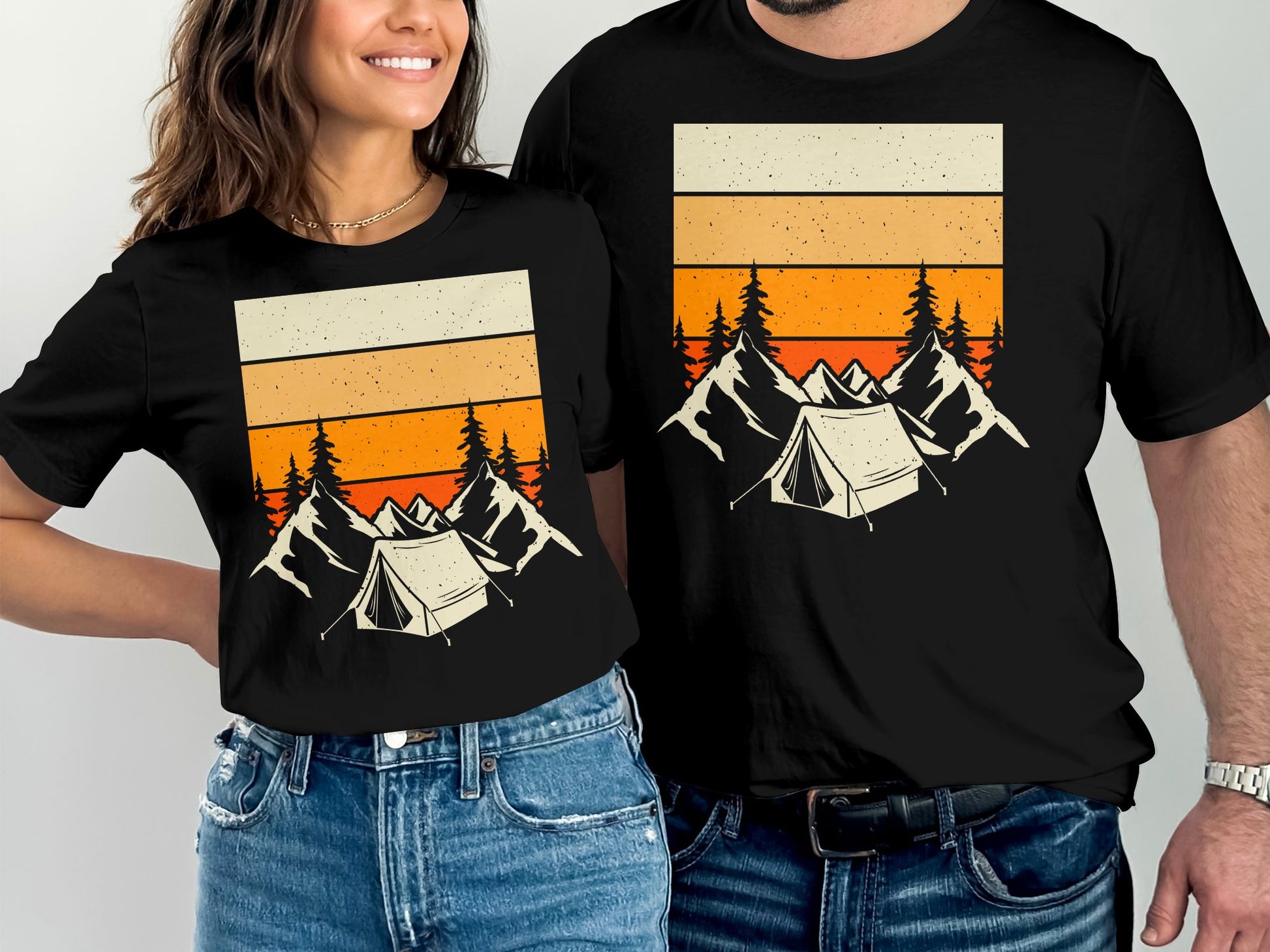 Matching black t-shirts with mountain and tent graphic featuring orange sunset stripes.