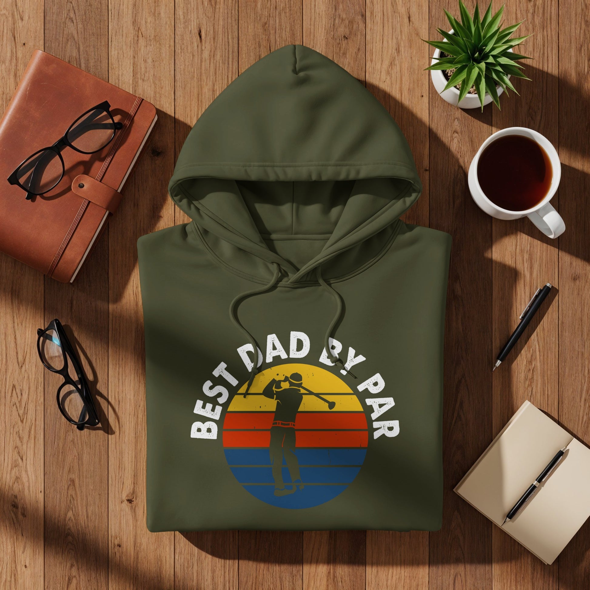 Olive green hoodie with "BEST DAD BY PAR" text and golf sunset graphic.