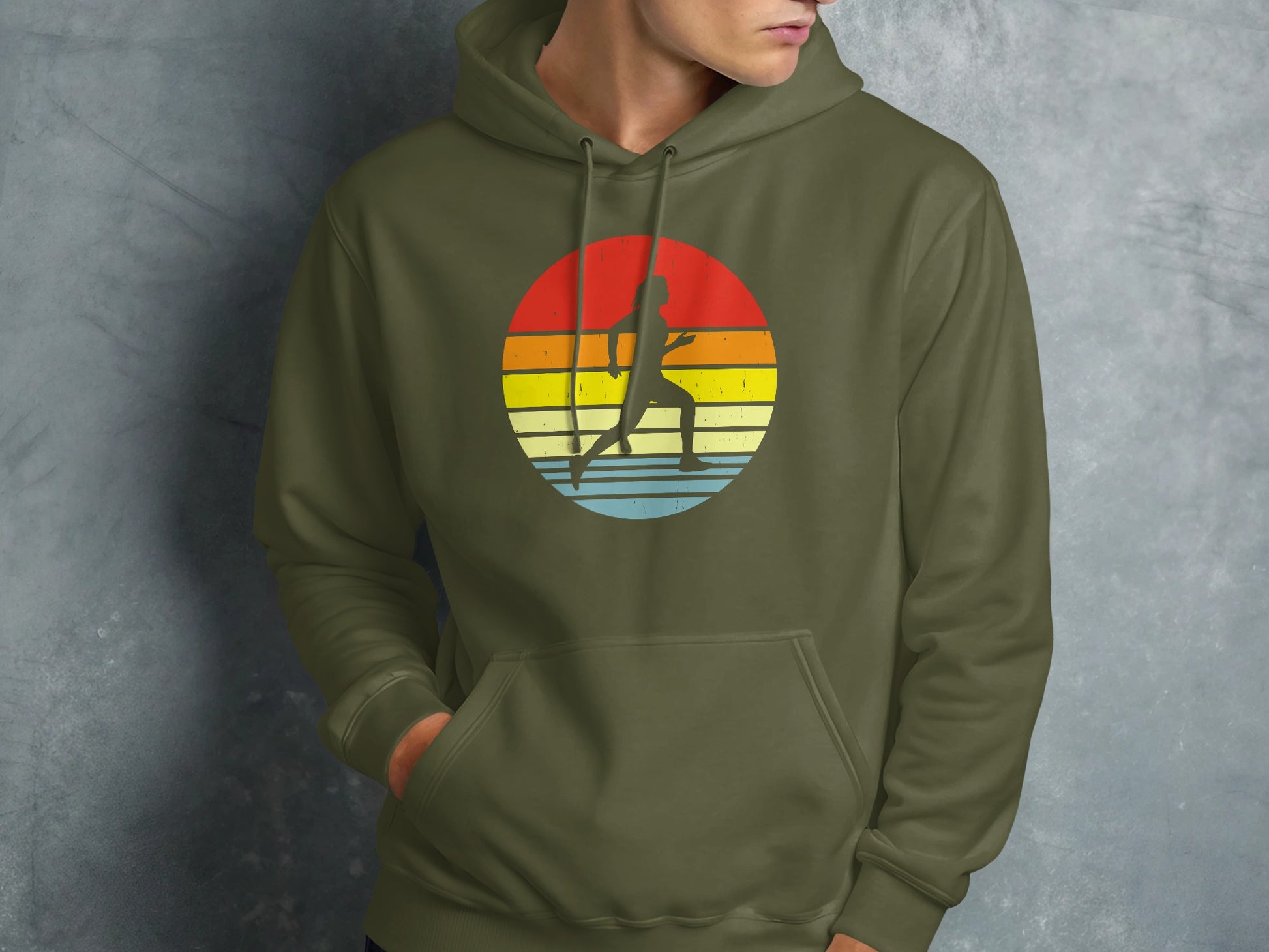 Green hoodie with silhouette of runner in a colorful sunset circle graphic.