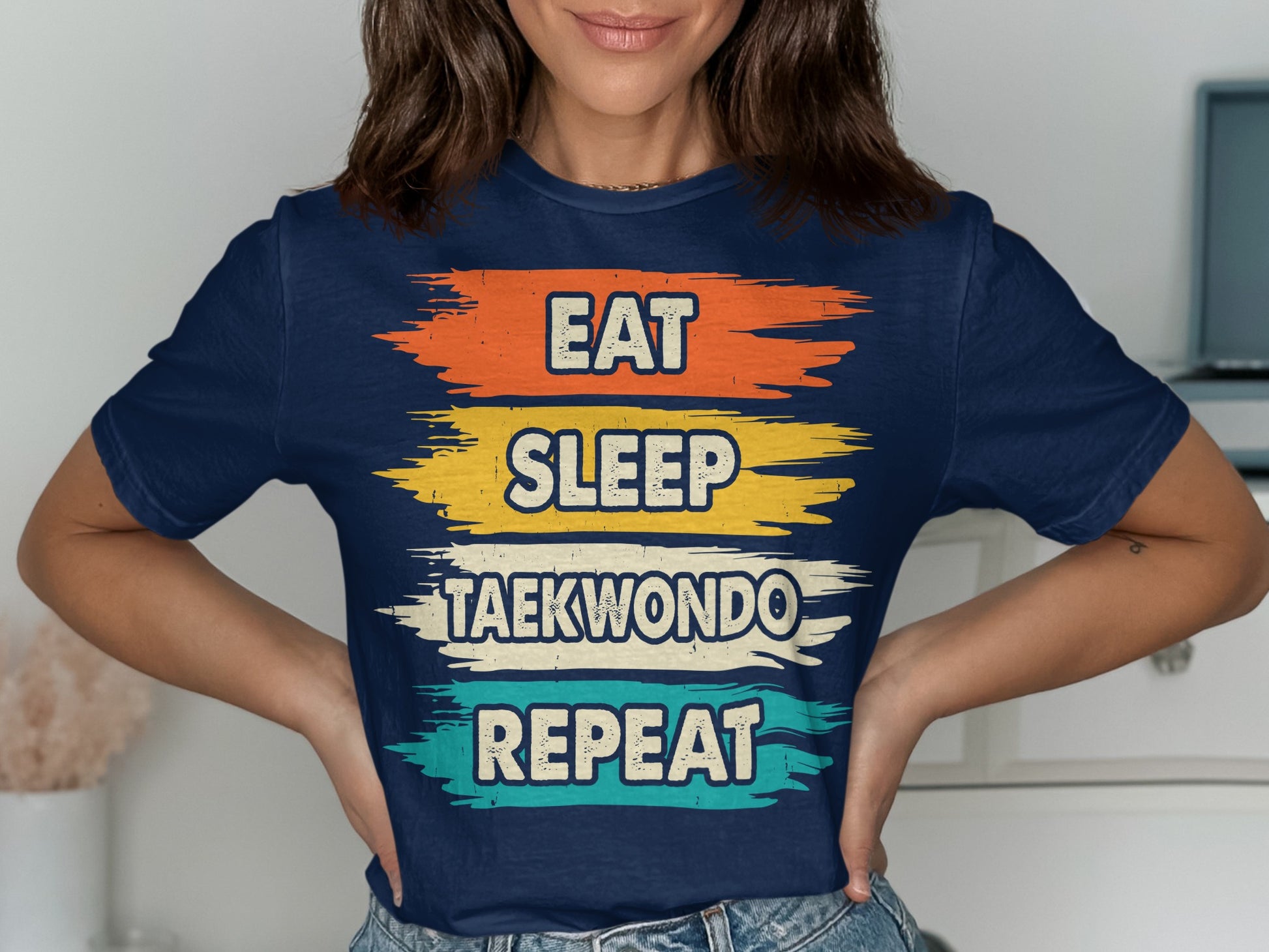 Navy t-shirt with "Eat Sleep Taekwondo Repeat" text in distressed brush strokes.