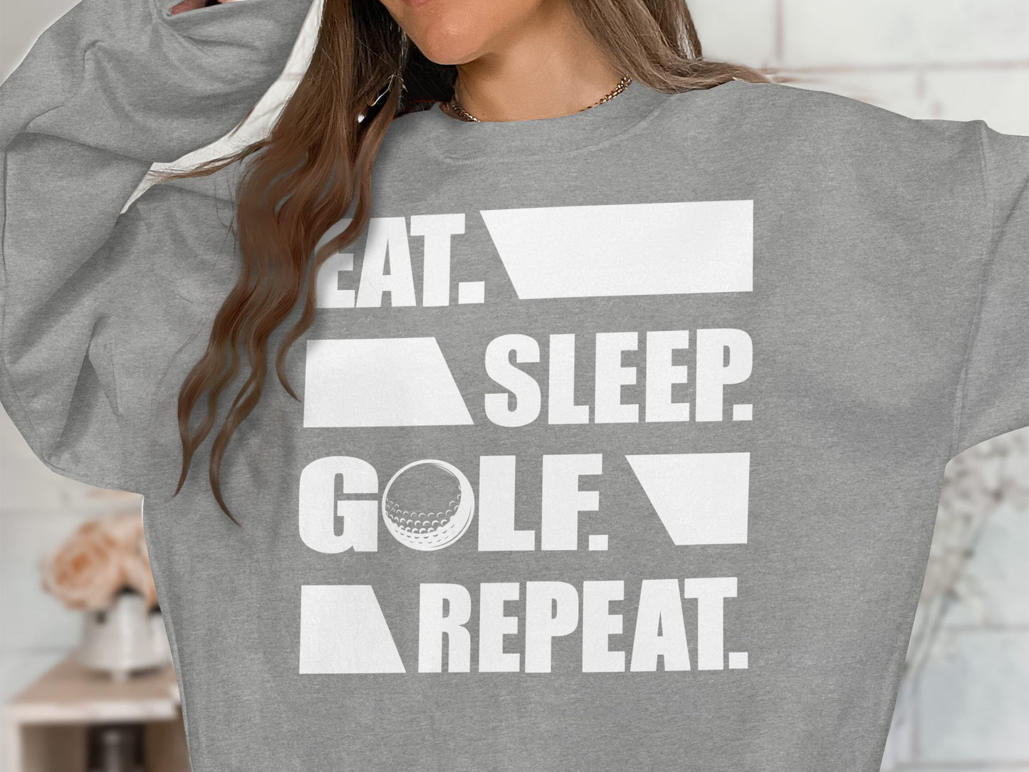 Gray sweatshirt with "EAT. SLEEP. GOLF. REPEAT." text and a golf ball.