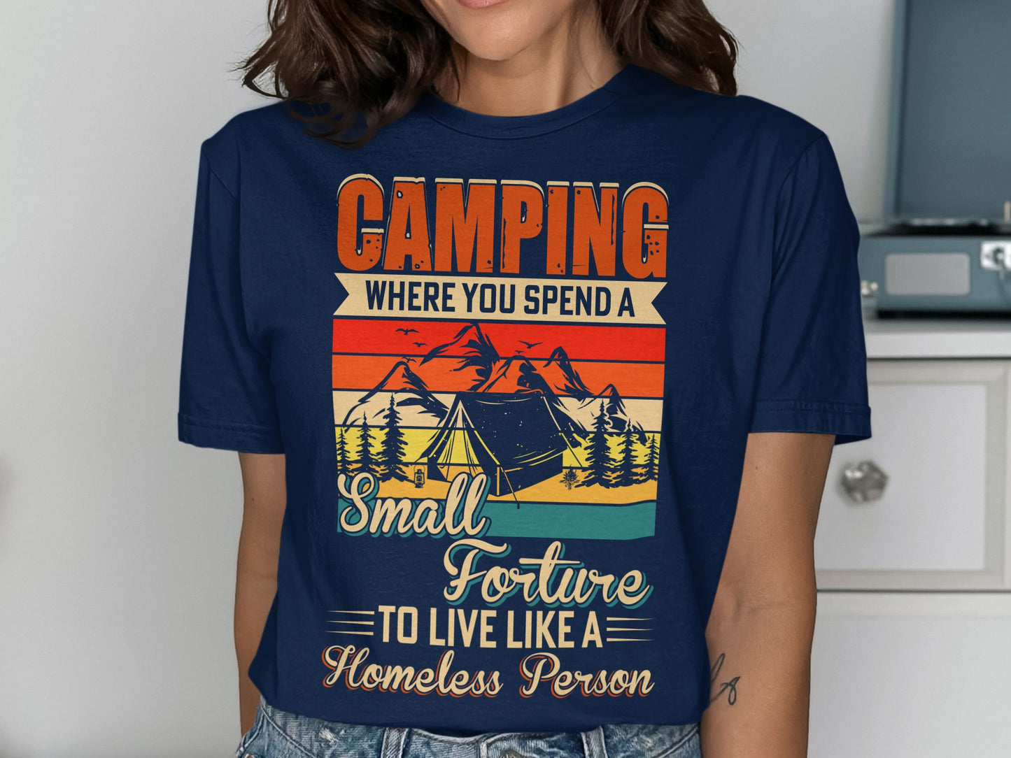 Navy t-shirt with "Camping Where You Spend a Small Fortune to Live Like a Homeless Person" graphic.