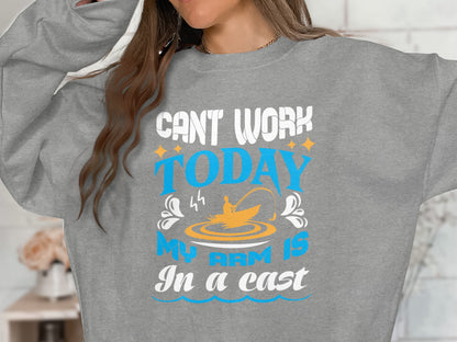 Grey sweatshirt with text "Can't work today, my arm is in a cast" and fishing graphic.